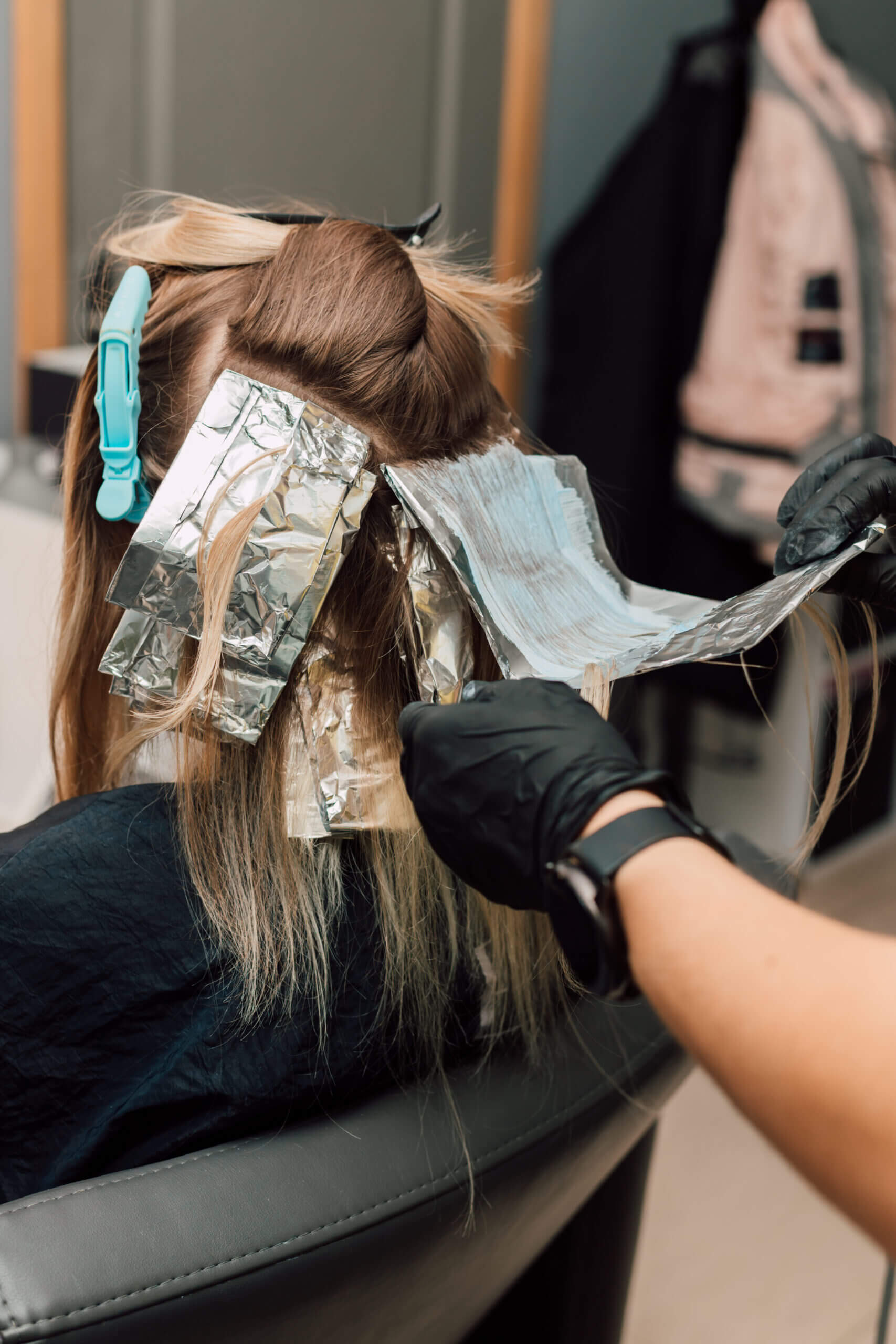 אישה לומדת לעשות פסים בשיער בצבע בלונד