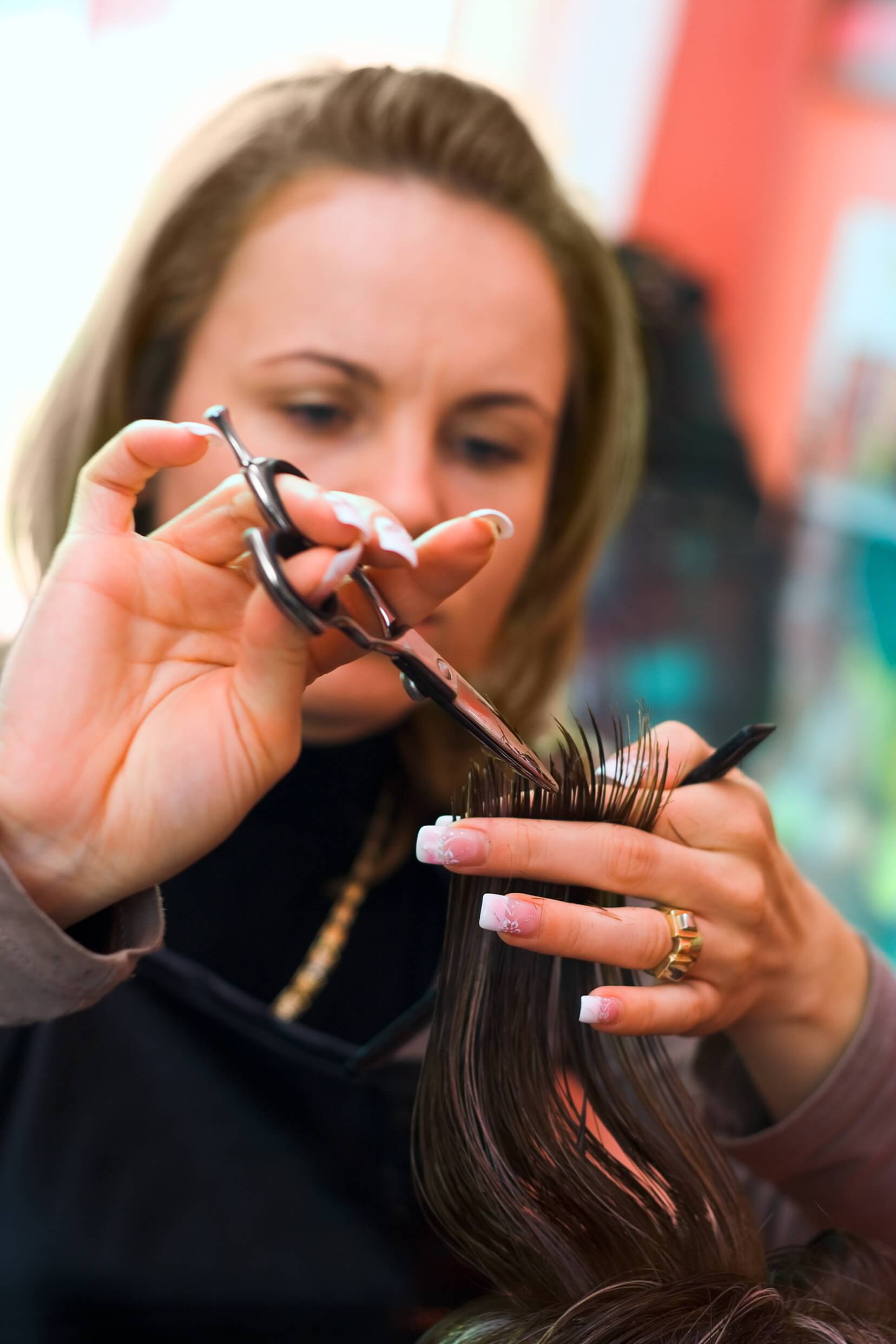 אשה מחזיקה מספריים ולומדת לגזור שיער